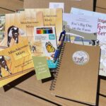 Book collection with bonus sketchbook, colored pencils, book mark, and post card.