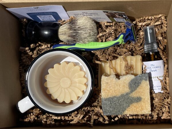 Men's shaving supplies: soap, mug, brush, razors, and aftershave oil.